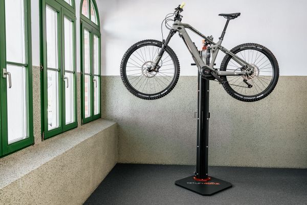 E-bike on the e-bike repair stand, electrically adjusted, on the top position